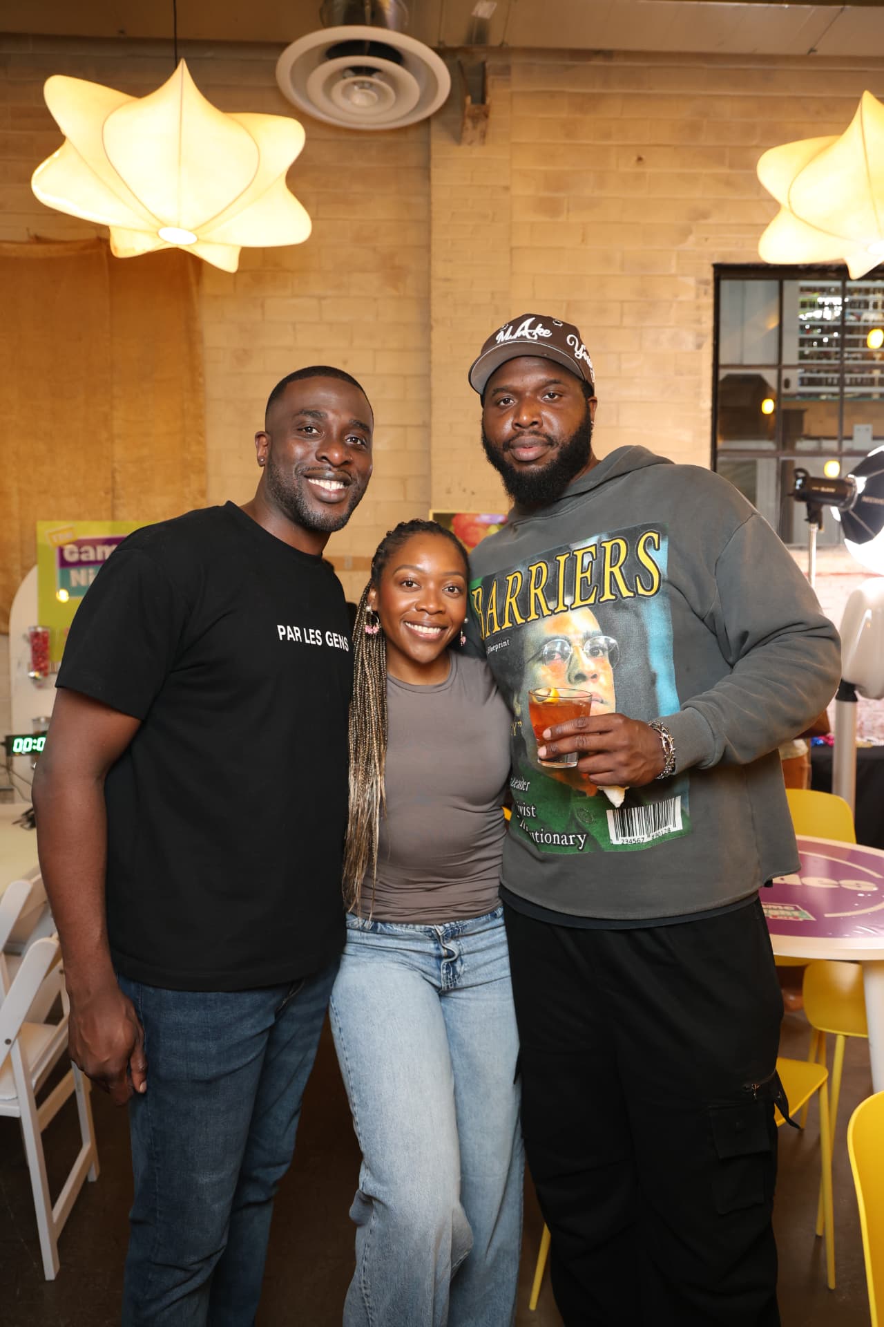 Three friends smiling together at a Game Night HTX event